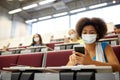 Student girl in mask with smartphone at lecture Royalty Free Stock Photo