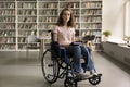 Student girl with mobility impairment posing for camera in library Royalty Free Stock Photo