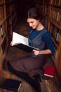 Student girl with open book in university library. Royalty Free Stock Photo