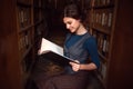 Student girl with open book in university library. Royalty Free Stock Photo