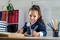 student girl politely listens to the teacher during the lesson in the classroom. Royalty Free Stock Photo