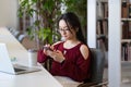 Student girl procrastinate in library with smartphone chat in social media not preparing for exam Royalty Free Stock Photo