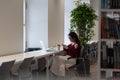 Student girl procrastinate in library with smartphone chat in social media not preparing for exam Royalty Free Stock Photo