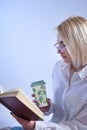 Young Woman Reading Book and Enjoying Hot Tea from Retro Cup: Education and Relaxation Concept