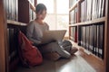 Student girl sitting on floor and using laptop, Writes notes for paper, Essay, Study for class assignment. Diverse group of Royalty Free Stock Photo