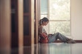 Student girl sitting on floor and using laptop, Writes notes for paper, Essay, Study for class assignment. Diverse group of Royalty Free Stock Photo