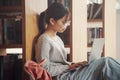 Student girl sitting on floor and using laptop, Writes notes for paper, Essay, Study for class assignment. Diverse group of Royalty Free Stock Photo