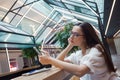 Student girl is sitting at a table and using an app on her smartphone.