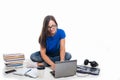 Student girl sitting working on laptop with books around Royalty Free Stock Photo