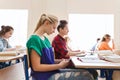 Student girl with smartphone texting at school Royalty Free Stock Photo