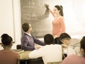 student girl solves task near blackboard in classroom mathematics Royalty Free Stock Photo