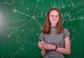 Student girl standing near clean blackboard in the classroom Royalty Free Stock Photo