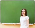 Student girl standing near clean blackboard in the classroom Royalty Free Stock Photo