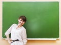 Student girl standing near clean blackboard in the classroom Royalty Free Stock Photo