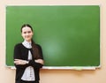 Student girl standing near clean blackboard in the classroom Royalty Free Stock Photo