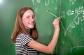 Student girl standing near clean blackboard in the classroom Royalty Free Stock Photo