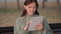 Student girl studying with tablet computer outdoors. Freelancer works online. Young woman works on a tablet in the park Royalty Free Stock Photo