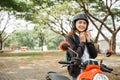 Student girl tightens helmet strap when going to ride