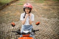 Student girl tightens rope while wearing helmet on motorbike