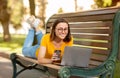 Student Girl Using Laptop Computer Lying On Bench In Park Royalty Free Stock Photo