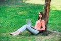 Student girl working with a laptop in a green park Royalty Free Stock Photo