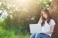 Student girl working with a laptop in a green park. Royalty Free Stock Photo