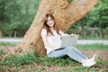 Student girl working with a laptop in a green park. Royalty Free Stock Photo