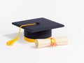 Student graduation cap and diploma scroll Royalty Free Stock Photo