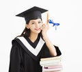 Student in graduation cap with stack of books