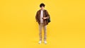 Student Guy Using Smartphone Listening Music Wearing Headphones, Yellow Background Royalty Free Stock Photo