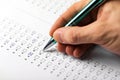 Student hand with pen fill in exam test answer sheet Royalty Free Stock Photo