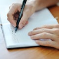 Student hand with a pen writing on notebook Royalty Free Stock Photo