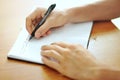 Student hand with a pen writing on notebook Royalty Free Stock Photo