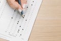 Student hand testing in exercise and passing exam carbon paper computer sheet with pencil in school test room, education concept Royalty Free Stock Photo