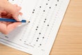 Student hand testing in exercise and passing exam carbon paper computer sheet with pencil in school test room, education concept Royalty Free Stock Photo