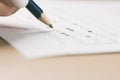 Student hand testing in exercise and passing exam carbon paper computer sheet with pencil in school test room, education concept Royalty Free Stock Photo