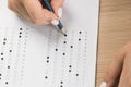 Student hand testing in exercise and passing exam carbon paper computer sheet with pencil in school test room, education concept Royalty Free Stock Photo