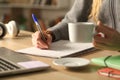 Student hands holding coffee cup writing at night Royalty Free Stock Photo