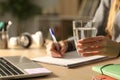 Student hands holding glass of water at night studying Royalty Free Stock Photo