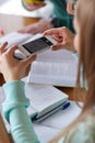 Student hands with smartphone making cheat sheet Royalty Free Stock Photo