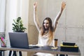 Student happy to accomplish creative task. Girl delighted to read great news online on laptop. Young professional hired by