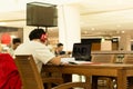 Student with headphones on doing home work in cafe with laptop