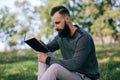 Student hipster bearded man reading a book outdoors Royalty Free Stock Photo