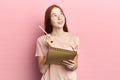 Student holding a pan and copy book and trying remember some information Royalty Free Stock Photo