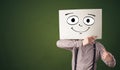 Student holding a paper with laughing emoticon in front of his face