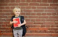 Student with large backpack near the school building. Back to school