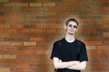 Student leaning against brick wall Royalty Free Stock Photo