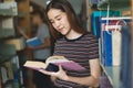 Student learning in library. Young woman read book in library for doing research assignment Royalty Free Stock Photo