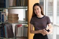 Student learning in library. Young woman read book in library for doing research assignment Royalty Free Stock Photo