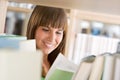 Student in library - cheerful woman read book